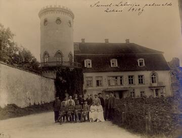 Leading employees of the Northern Latvian Civil Administration at Cēsis Castle in June 1919. Seated from left: 1.- Aleksandrs Pētersons, 2.- Hugo Celmiņš, 3.- Markus Gailītis, 4.- Ādolfs Vickofs. Standing from left: 4.- Vilis Gulbis. Source: Latvian War Museum.
