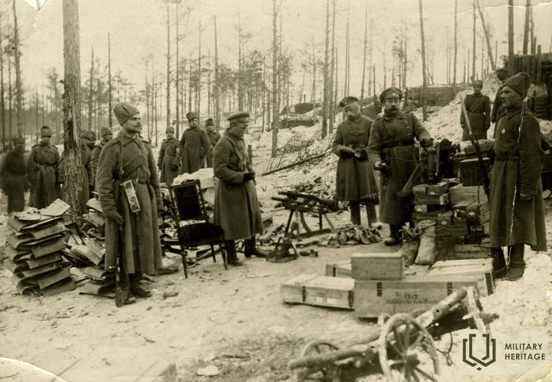 Latviešu strēlnieki ieņemtajā Ložmetējkalnā ar iegūtajām trofejām. 1917. Latvijas Kara muzejs