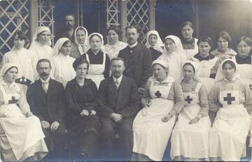 Dr. med. Eduards Akermanis  pirmajā rindā vidū, kreisajā pusē viņa sieva ārste Verena Treigute-Akermane un personāls pie lazaretes ēkas Cēsīs, Piebalgas ielā 6, 1917. gadā. Foto no Cēsu muzeja krājuma, CM 63483.