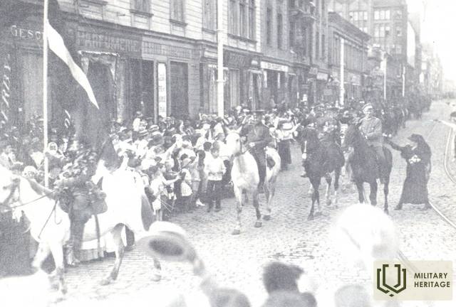 Ziemeļlatvijas brigādes ieiešana Rīgā 1919. g. 6.jūlijā. Otrajā baltajā zirgā brigādes virspavēlnieks Jorģis Zemitāns. Fotogrāfs Jānis Rieksts. Foto no Cēsu Vēstures un mākslas muzeja.