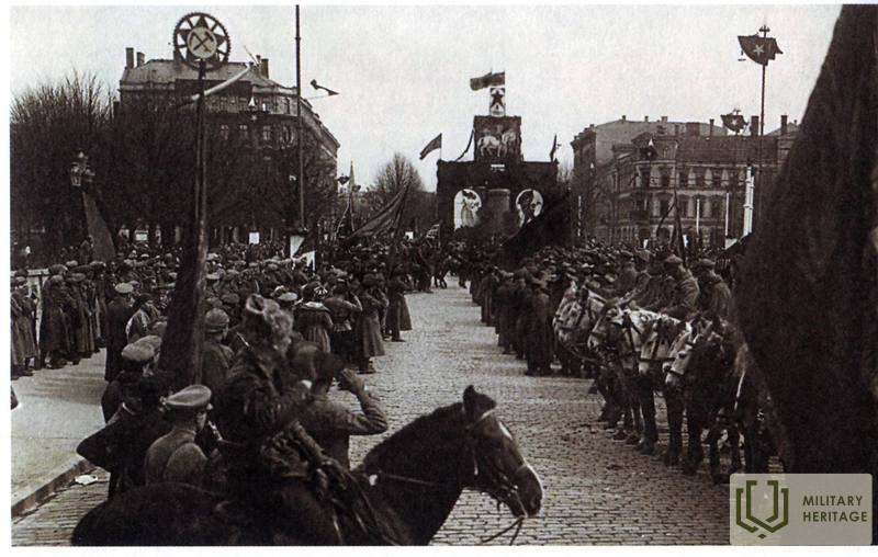 Latviešu sarkanie strēlnieki 1919. gada 1. maija parādē Rīgā pie bijušā Pētera I pieminekļa (tagad laukums pie Brīvības pieminekļa). Avots: Wikipedia.